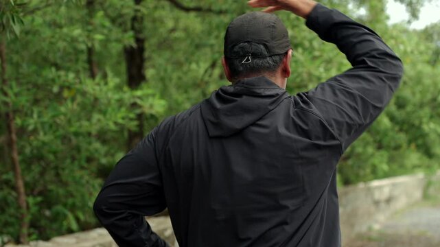 Happy active senior man warming up and stretching outdoors before exercise. Healthy aging, fitness. Longevity retirement lifestyle, preventive health, life insurance and joyful life after retirement.
