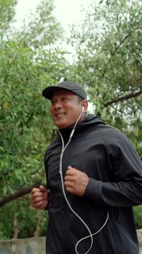 Happy active senior man jogging in nature after retirement. Healthy aging, fitness. Longevity outdoor lifestyle, preventive health, retirement happiness. Life insurance and financial security concept.