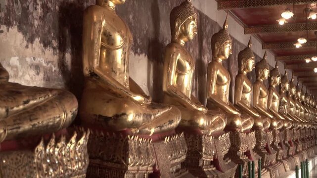 Row of ancient buddha statues in buddhist temple