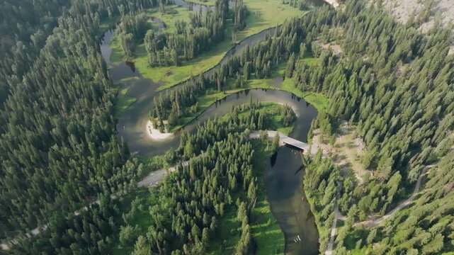 Aerial view of a winding river flowing through a dense pine forest in McCall, Idaho, United States.