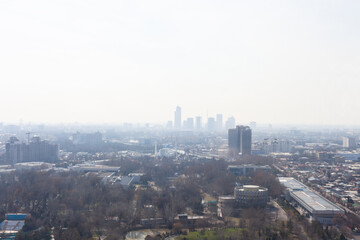 Fototapeta premium Hazy city skyline with mountains on distant horizon