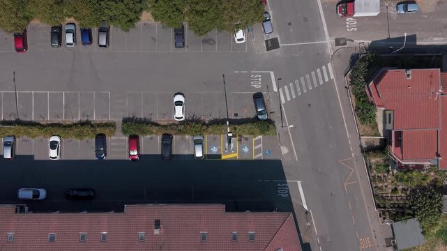 Aerial View of Parking Lot: An aerial perspective showcases a bustling parking lot filled with cars, adjacent to a street with a crosswalk and nearby buildings, Mediglia, Milan, Italy