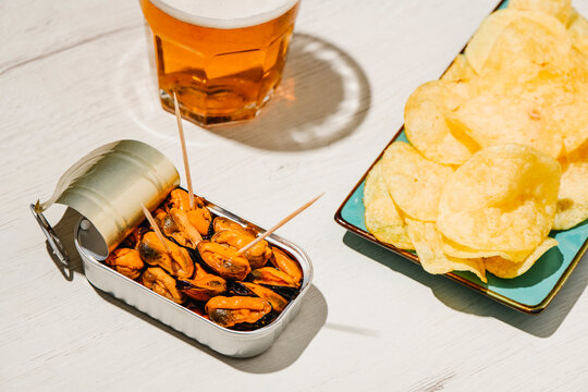 mussels, beer and chips on a table