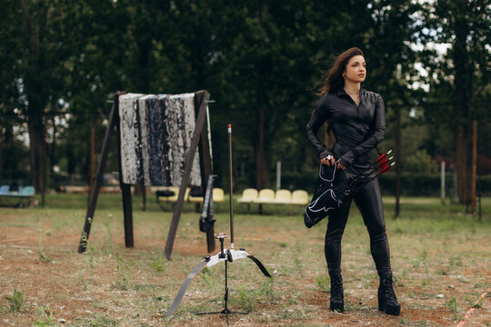 Woman archer holding quiver with arrows outdoors