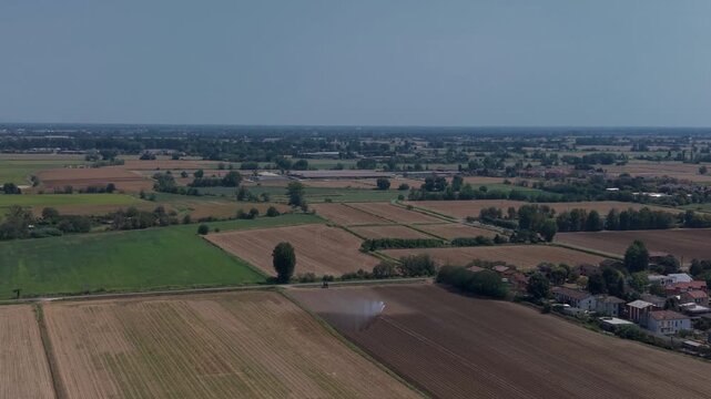 Vast Agricultural Landscape: An expansive aerial view showcases a patchwork of cultivated fields and rural settlements under a clear blue sky, Mediglia, Milan, Italy