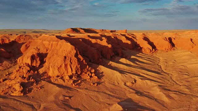 Aerial view of the iconic red sandstone formations of the Flaming Cliffs at sunset in Bulgan, Omnogovi, Mongolia.