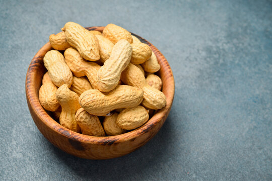 Wooden bowl with peanuts in the shell. Nuts Close-up.