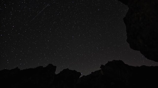 Night Sky Timelapse of Perseid Meteor Fireball and Stars over Rocky Mountain Silhouettes
