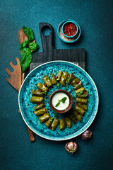Fototapeta premium Traditional delicious Turkish foods: dolma (sarma) stuffed grape leaves rice. Close up. On a dark background.