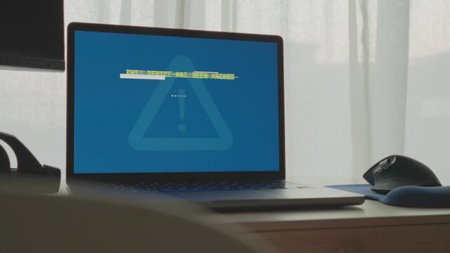 Laptop computer is hacked and displays message on screen of system breach. Hacker group or spy agency cyber team breaking into server or personal pc in house or office. Warning and ransom request