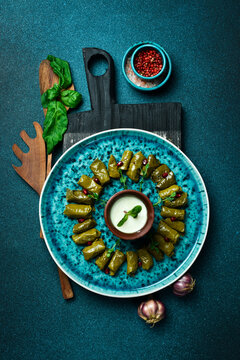 Traditional delicious Turkish foods: dolma (sarma) stuffed grape leaves rice. Close up. On a dark background.