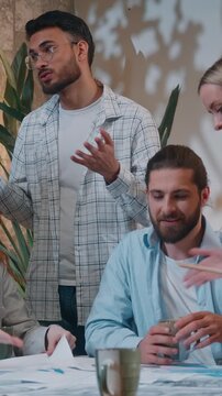 Stressed busy multiracial five coworkers in startup office casual informal business process women men talking discussing papers documents chaos group colleagues coworking working paperwork development