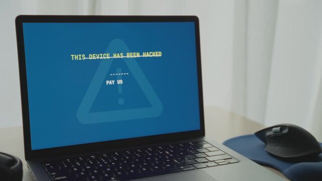 Laptop computer is hacked by cyber criminal team requesting ransom from user. Alert message pops on screen asking for money in order to release blocked personal private data. Virus or ransomware crime
