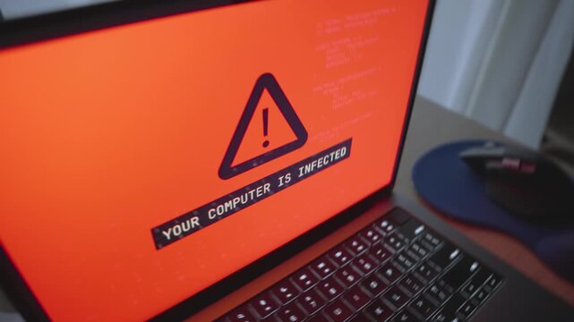 Close up on laptop computer displaying warning message of cyber virus infection. Hacker group or cyber criminals remote accessing computer installing malware to steal private data and ask for ransom
