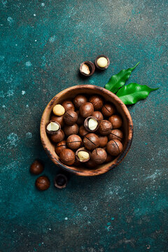 Macadamia nuts in wooden bowl on textured background. Copy space. Superfood, vegan, vegetarian food concept.Healthy snack.