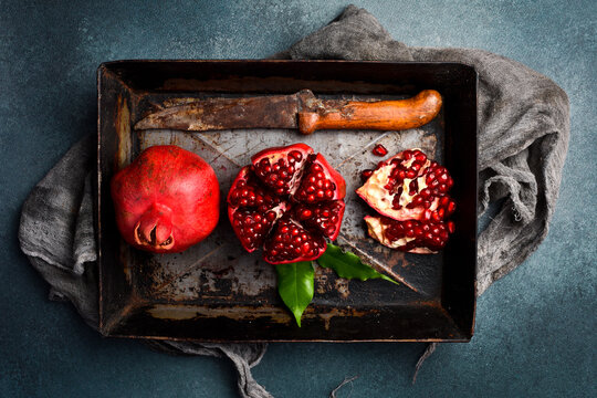 Ripe pomegranate fruits on a tray. Rustic style. Creative fruit photo.