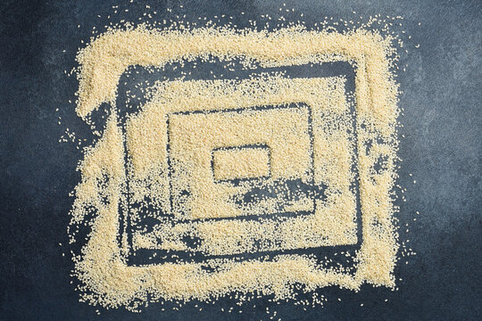 Sesame seeds arranged in a frame with free space for text. On a gray concrete background.