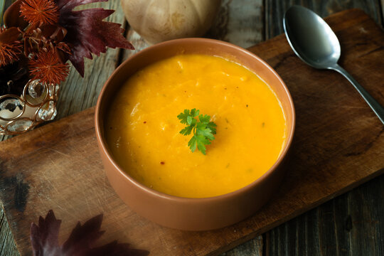 Bowl of pumpkin soup. Tradition autumn food, vegetable cream soup. Thanksgiving dinner in rustic style