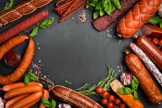 Assortment of salami and snacks. Sausage Fouet, sausages, salami, paperoni. On a black wooden background. Top view. Free space for your text.