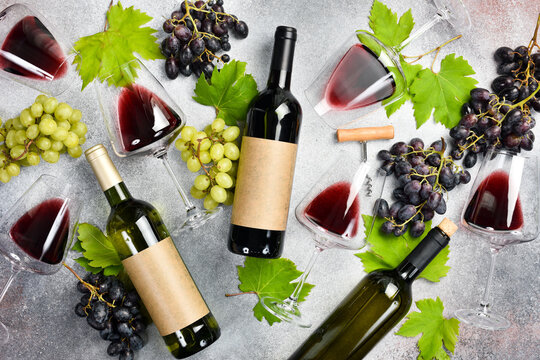 Bottled wine, bunch of grapes, glasses, corkscrew and corks. Top view.