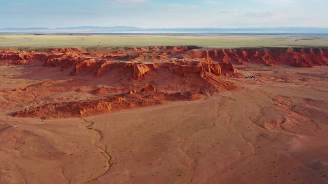 Aerial view of the Flaming Cliffs, featuring red sandstone formations, vast desert landscape, and arid terrain in Bulgan, Omnogovi, Mongolia.