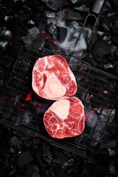 Raw Ossobuco veal steak on a background of hot coals. Top view. Meat Close-up.