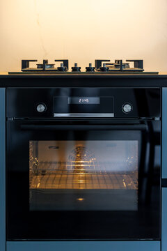 Built-in oven with gas cooktop. Modern kitchen appliance with warm interior light.