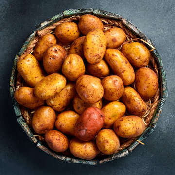 Organic food. Basket with raw potatoes. Top view, close-up.