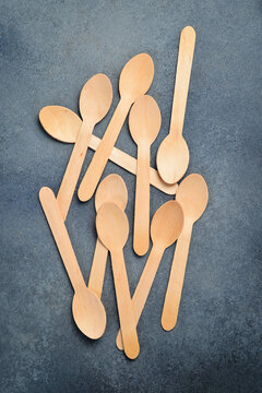 Wooden spoons. The concept of environmental protection. On a gray stone background, top view.
