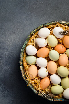 Raw organic chicken eggs on hay in a wooden box. Close up.