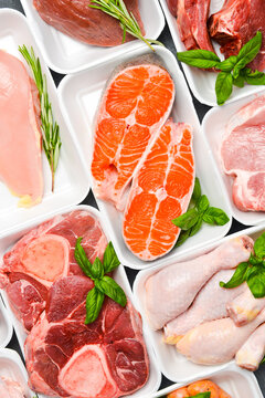 Various raw meat and fish in packaging trays from supermarket. Top view. Food background.