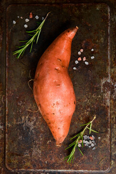 Raw sweet potatoes on a metal tray. Organic farm potatoes.