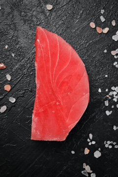 Raw fresh tuna fish steaks set. On black slate background. Close up, Top view.