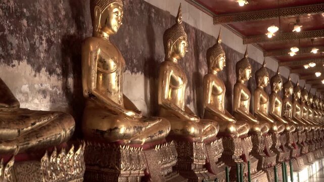 Row of ancient buddha statues in buddhist temple