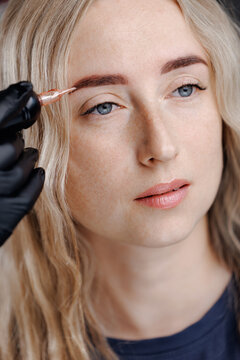 Woman receiving eyebrow tattooing in treatment permanent studio