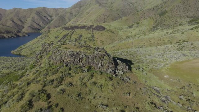 Aerial view of the rocky ridges and green hills surrounding Lucky Peak Lake in Ada County, Idaho, United States.