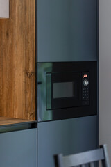 Built-in microwave in a modern kitchen. Dark cabinets with warm wood.