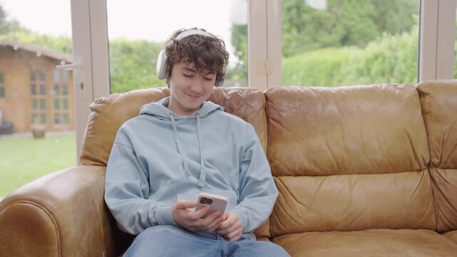 Teenagaer in headphones staring at phone and isn&rsquo;t paying any attention, while mother is trying to call him, shouting at teen, concept of generation gap and communication problems