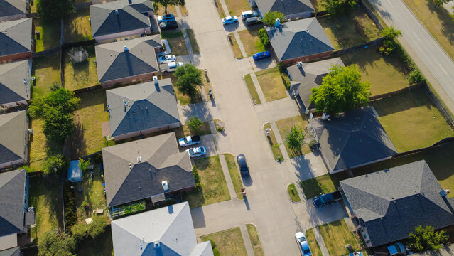 Paved turnaround cul de-sacs anchor quiet residential blocks along Nicole Court. Dark composite shingle roofs cover tidy brick residences beside green lawns, parked trucks, Arlington, Texas