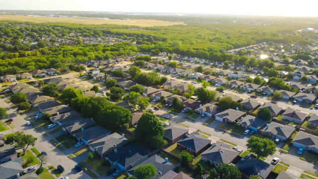 Curving suburban cul de-sacs branch through Charles City neighborhood near green woodland belts. Compact single story properties feature asphalt driveways, neat lawns, Arlington, Texas