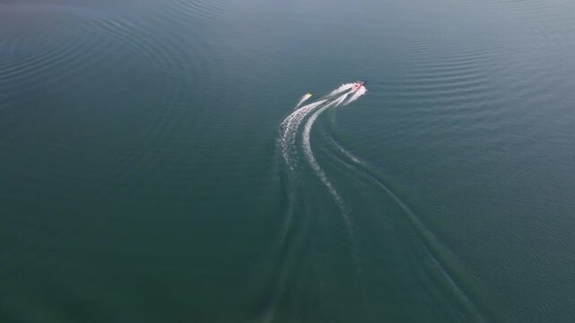 Aerial view of a motorboat cruising on the calm blue waters of Lucky Peak Lake, leaving a white wake in Ada County, Idaho, United States.