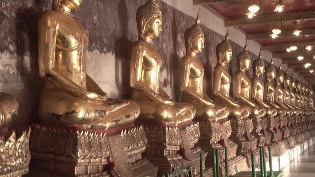 Row of ancient buddha statues in buddhist temple