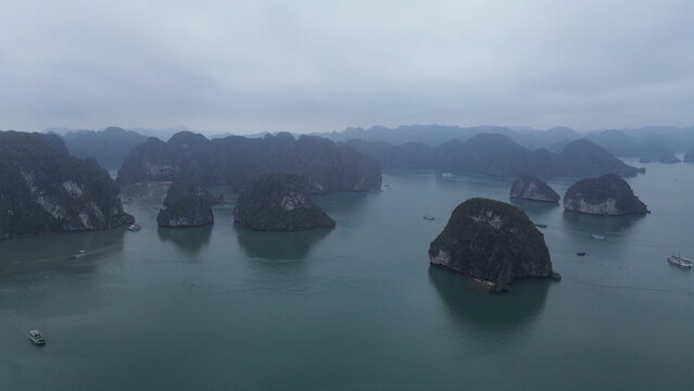 Panoramic drone shot of Ha Long Bay limestone karsts protruding from blue sea, Vietnam
