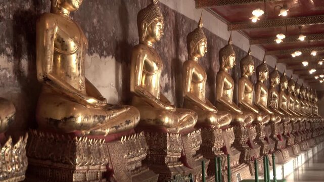 Row of ancient buddha statues in buddhist temple