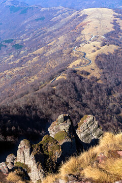 View of the winding road through the Stara planina mountain range with rocky foreground and autumn landscape in Babin zub, Pirot District, Serbia.