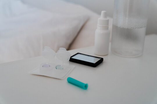 Orthokeratology night lenses in a contact lens case with a sleep mask in the background. Overnight corneal reshaping supports myopia control and vision correction