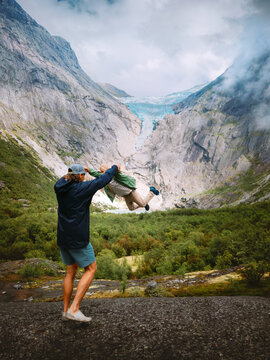 Father and daughter having fun in mountains travel together in Norway family vacations outdoor, parent and child playing enjoying Briksdalsbreen glacier view explore Stryn trails, candid moments