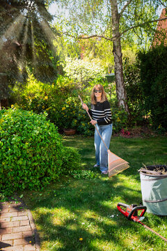 Full length of a mid-aged woman gardening at the back yard