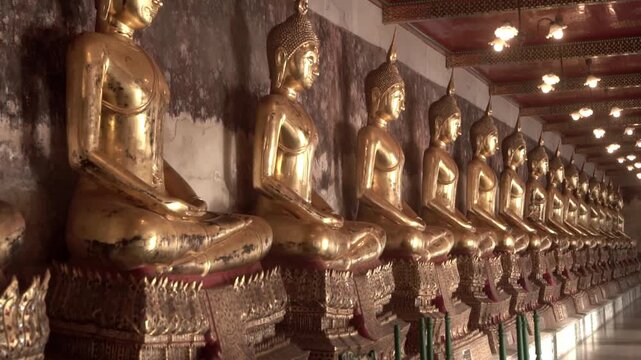 Row of ancient buddha statues in buddhist temple