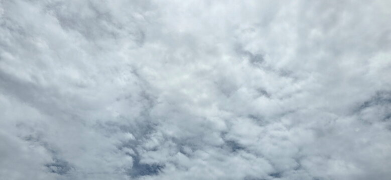 A cloudy sky. Stratocumulus clouds, or Altocumulus, are wavy or puffy, grayish-white clouds. Rounded masses clustered together in panels or waves of grayish-white color. Altostratus (Thick gray sheet)